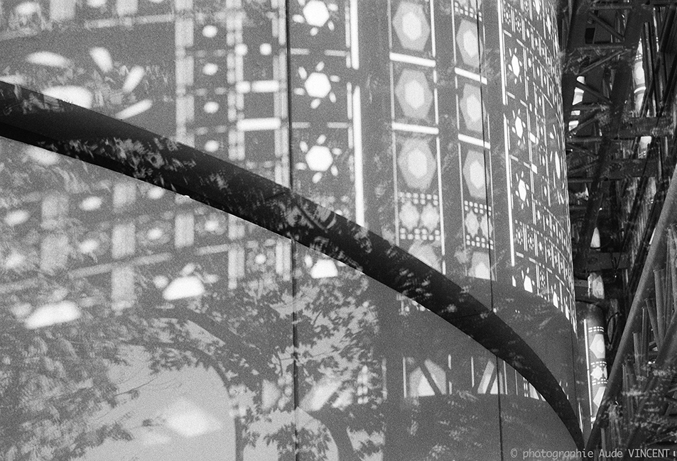 Photographie d’auteur argentique noir et blanc extraite de la série « Paris, Paris, Paris, la ville lumière sans cliché » de la photographe française et parisienne Aude VINCENT.  L’institut du Monde Arabe (IMA) est un institut culturel parisien consacr