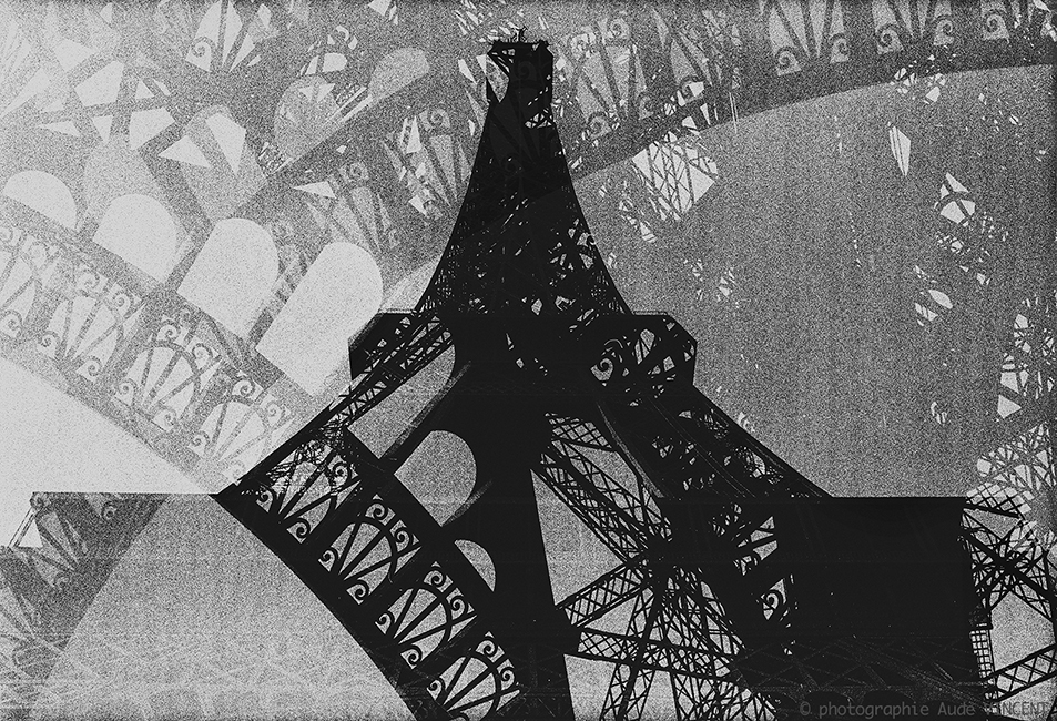 Photographie d’auteur argentique noir et blanc extraite de la série « Paris, Paris, Paris, la ville lumière sans cliché » de la photographe française et parisienne Aude VINCENT.La Tour Eiffel à Paris.