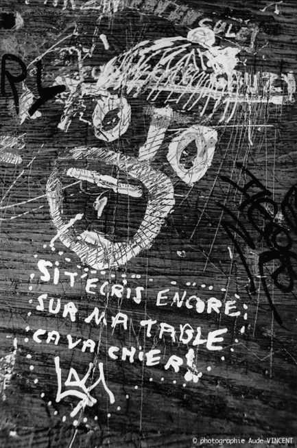 photographie en noir & blanc extraite de la série « Les pupîtres de la nation » : les graffitis laissés sur les tables d’école par les lycéens.