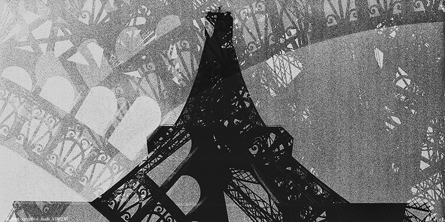 Photographie d’auteur argentique noir et blanc extraite de la série « Paris, Paris, Paris, la ville lumière sans cliché » de la photographe française et parisienne Aude VINCENT.La Tour Eiffel à Paris.